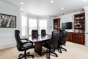 a conference room with a table and chairs and a television at Brickshire Apartments, Merrillville, IN, 46410